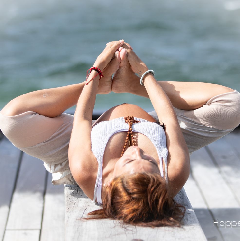 Gravid kvinde dyrker yoga på stranden Hoppes Photo
